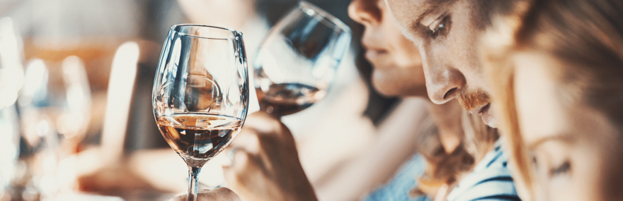 A group of people tasting wine and taking notes